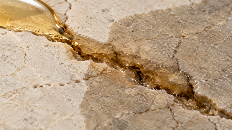 Low-viscosity epoxy resin flowing into cracks and pores of natural stone, illustrating resin penetration for stone repair and infusion.